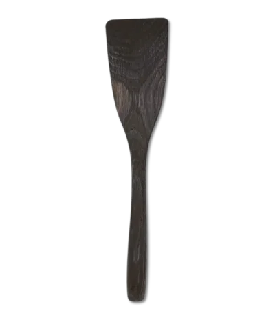 Hand-carved long wooden kitchen spatula made from smoked oak, lying flat on a neutral background.