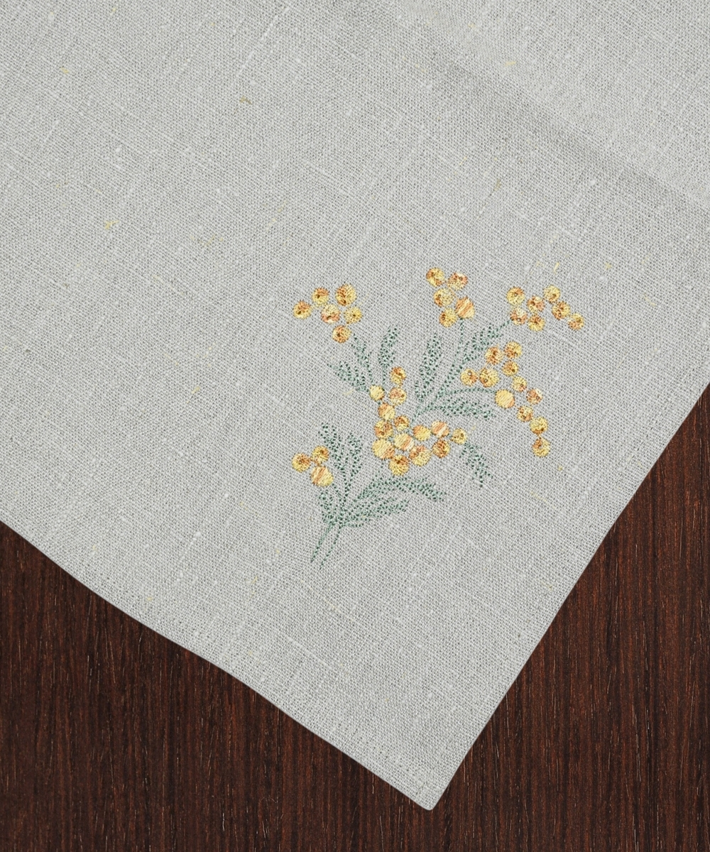 Close up of sea buckthorn embroidery on linen towel
