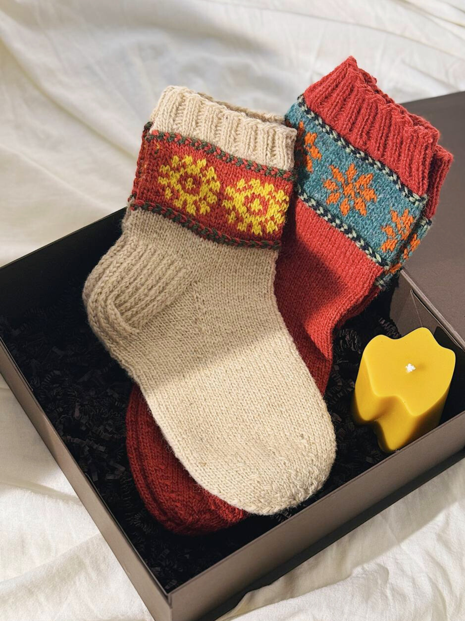 Hand-knitted wool socks presented as a sustainable gift in a gift box.